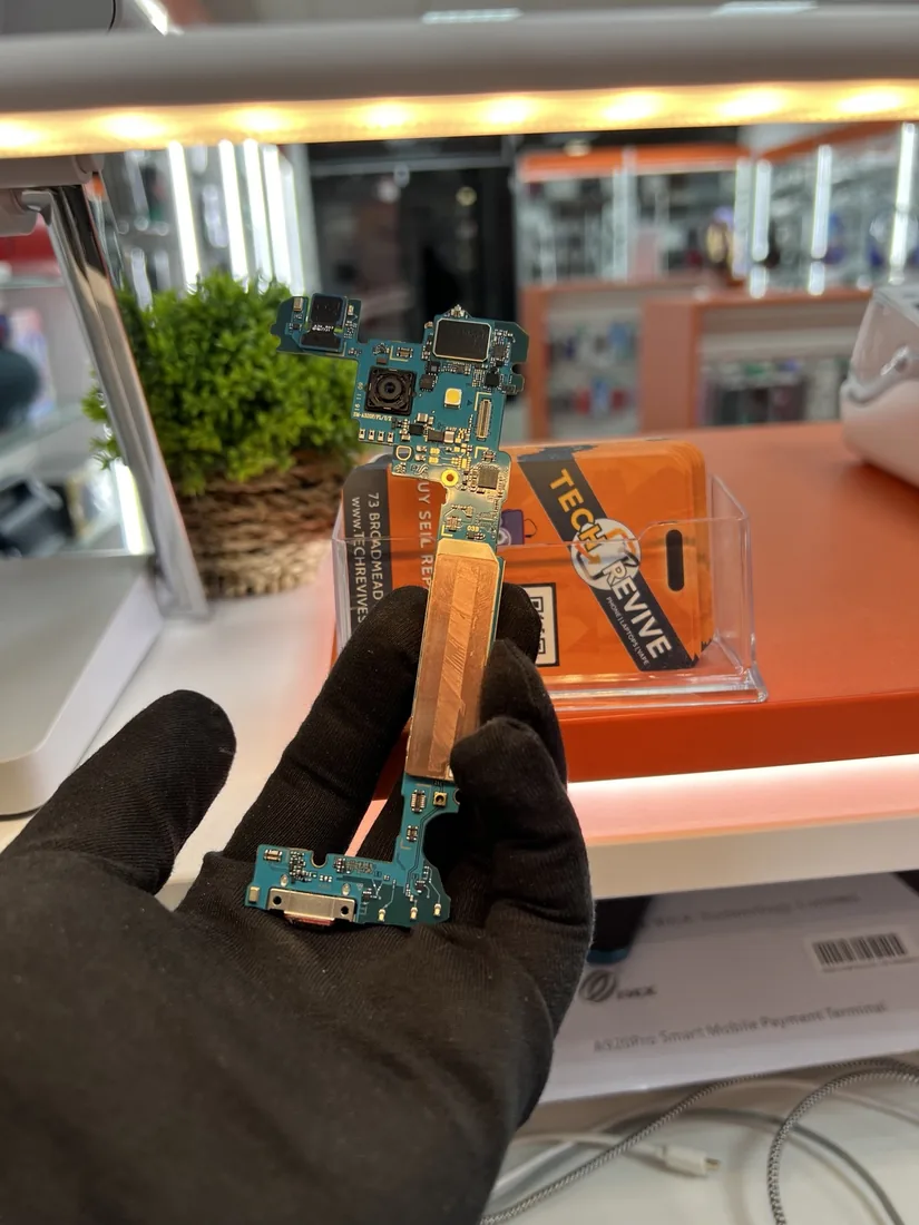 Technician repairing an electronic device at the Tech Revive workbench